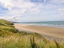 A beach scene with grass and waves at Maerdy Cwtch in Haverfordwest