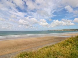 A beach with ocean waves and clouds at Maerdy Cwtch in Haverfordwest