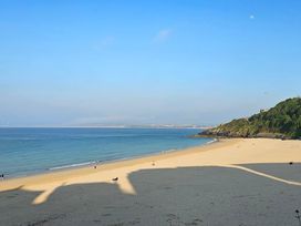 A beach with ocean and hills at Dog-friendly lodge, steps to St Ives train in Hayle
