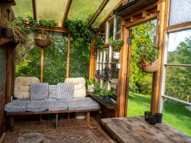 A conservatory with a sofa and plants at Hapus Yurt - Two Beautiful Yurts and Barn Cottage