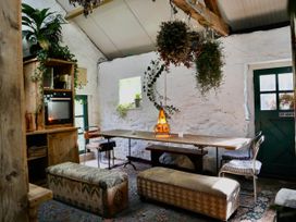 A dining room with a wooden table and plants at Hapus Yurt - Two Beautiful Yurts and Barn Cottage 