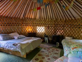 A bedroom with beds and a wood stove at Hapus Yurt - Two Beautiful Yurts and Barn Cottage