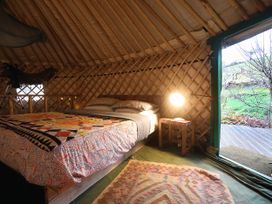 A bedroom with a bed and a lamp at Hapus Yurt - Two Beautiful Yurts and Barn Cottage 