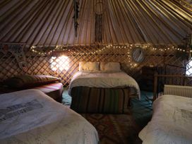 A bedroom with beds and a mirror at Hapus Yurt - Two Beautiful Yurts and Barn Cottage