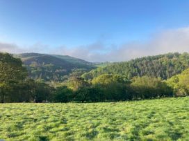 A landscape view of hills and trees with grass in the foreground at Hapus Yurt - Two Beautiful Yurts and Barn Cottage