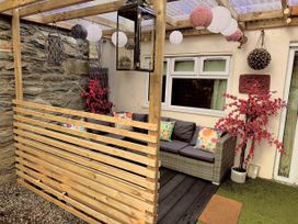 An outdoor seating area with a sofa and cushions at Zip Cottage Sleeps 2-3 climb snowdon zip world