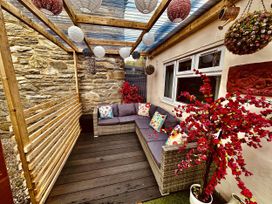 An outdoor seating area with a sofa and decorative plants at Zip Cottage Sleeps 2-3 climb snowdon zip world