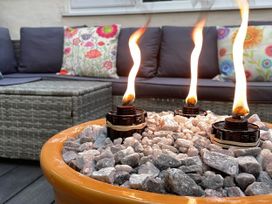 An outdoor lounge area with a fire pit and seating at Zip Cottage Sleeps 2-3 climb snowdon zip world