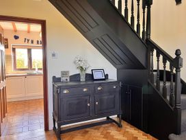 A hallway with a cupboard and staircase at Dog-friendly farmhouse with Menai Strait views