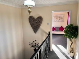 A hallway with heart wall decor and a potted plant at Dog-friendly farmhouse with Menai Strait views