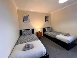 A bedroom with two beds and a bedside table at Dog-friendly farmhouse with Menai Strait views