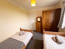 A bedroom with two single beds and wooden furniture in a dog-friendly farmhouse with Menai Strait views