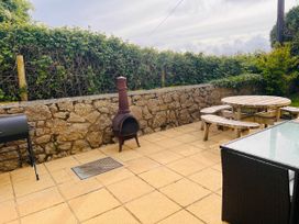 An outdoor patio with a table and benches at Dog-friendly farmhouse with Menai Strait views