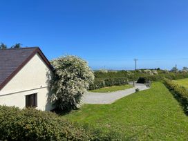 A house with a garden and pathway at Cottage with mountain and sea views, Anglesey
