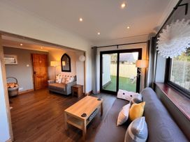 A living room with a sofa, coffee table, and window at Cottage with mountain and sea views, Anglesey