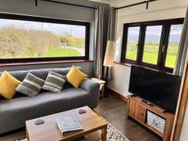 A living room with a sofa and television at Cottage with mountain and sea views, Anglesey