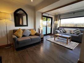 A living room with sofas and a coffee table at Cottage with mountain and sea views, Anglesey