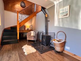 An entrance hall with a staircase and fireplace at Cottage with mountain and sea views, Anglesey