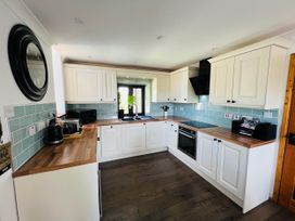 A kitchen with cabinets and appliances at Cottage with mountain and sea views, Anglesey