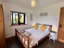 A bedroom with a bed and window at Cottage with mountain and sea views, Anglesey