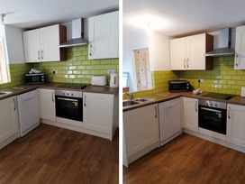 A kitchen with cabinets and appliances at Surf-ready apartment with sea views in town