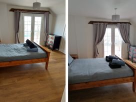 A bedroom with a bed and sliding doors at Surf-ready apartment with sea views in town