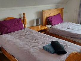 A bedroom with two beds and a nightstand at Surf-ready apartment with sea views in town