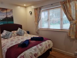 A bedroom with a bed and window at Riverside cottage with otters near Tintagel