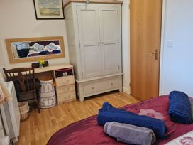 A bedroom with a bed and furniture at Riverside cottage with otters near Tintagel