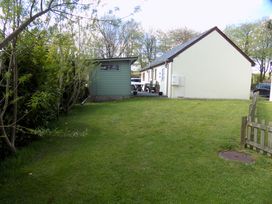 A garden with a house and shed at Riverside cottage with otters near Tintagel