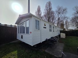 A mobile home exterior with windows and a lawn at Beach holiday base with pool and kids' activities