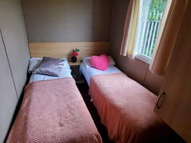 A bedroom with two beds and a flower on a table at tbc in 