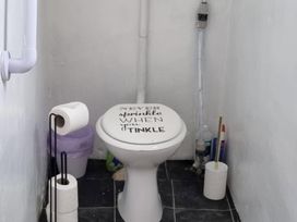 A bathroom with a toilet and toilet paper holder at tbc