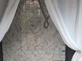 A shower area with tiles and a shower caddy at tbc