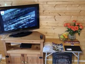 A living room with a television and shelf unit at tbc 