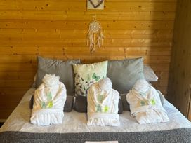 A bedroom with towels arranged on the bed at tbc