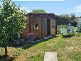 A garden shed with a table and chairs at tbc 