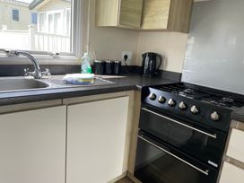 A kitchen with a sink and stove at tbc 