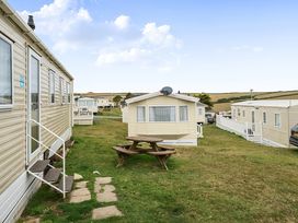 A mobile home with a picnic table and grass area near Pet-friendly lodge near Fistral Beach Fistral Beach, Newquay