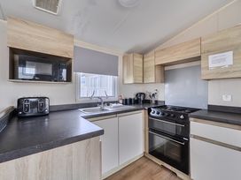 A kitchen with appliances including a cooker and microwave at Pet-friendly lodge near Fistral Beach, Fistral Beach, Newquay