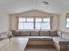 A living room with a sectional sofa and coffee table at Pet-friendly lodge near Fistral Beach, Fistral Beach, Newquay