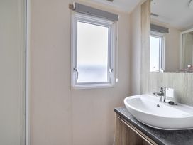A bathroom with a sink and mirror at Pet-friendly lodge near Fistral Beach, Fistral Beach, Newquay