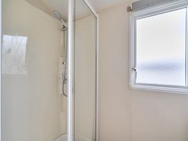 A shower with glass door and window at a pet-friendly lodge near Fistral Beach