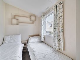A bedroom with two beds and a window at Pet-friendly lodge near Fistral Beach, Fistral Beach, Newquay