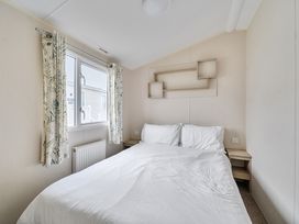 A bedroom with a bed and window at Pet-friendly lodge near Fistral Beach, Fistral Beach, Newquay