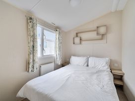 A bedroom with a bed and window at Pet-friendly lodge near Fistral Beach, Fistral Beach, Newquay