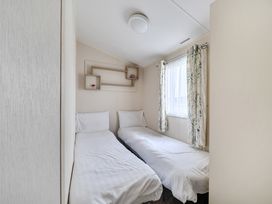 A bedroom with two single beds and a window at Pet-friendly lodge near Fistral Beach, Fistral Beach, Newquay