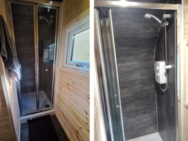 A shower with a glass door and shower head at tbc