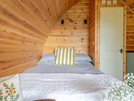 A bedroom with a bed and wooden wall at Peaceful pod with bay views, walk to 3 beaches, St Ives