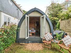 A garden with a pod structure and seating area at Peaceful pod with bay views, walk to 3 beaches St Ives